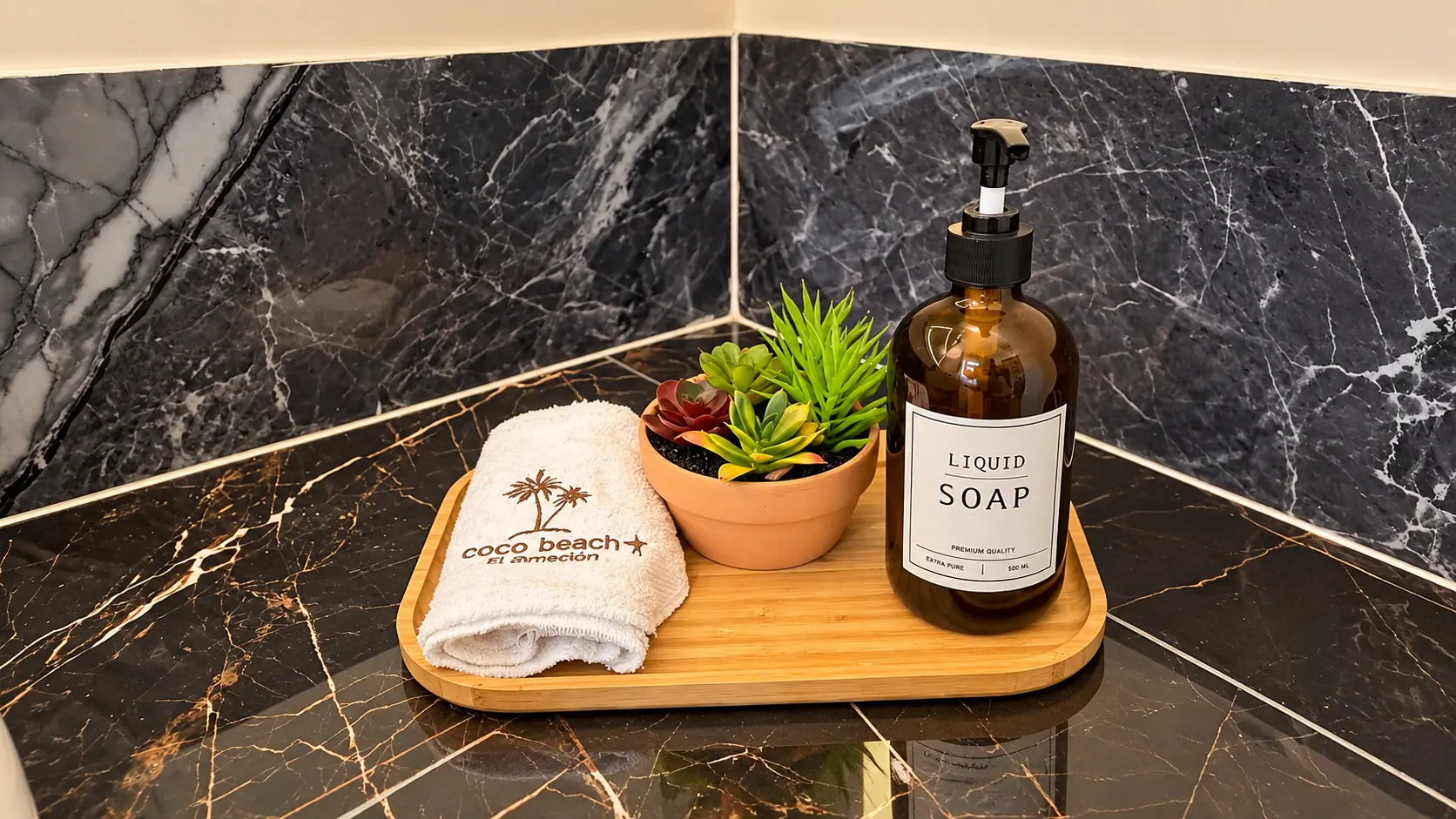 Bandeja de bienvenida con toalla bordada, planta y jabón en Coco Beach